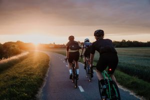 Gruppe Radfahrer bei Sonnenuntergang auf Landstraße